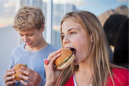 simsearch:6108-06907036,k - Close-up of two friends eating hamburger Stock Photo - Premium Royalty-Free, Code: 6108-06905195