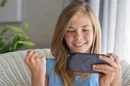 simsearch:6108-06905230,k - Close-up of a smiling girl playing video game Stock Photo - Premium Royalty-Free, Code: 6108-06905199