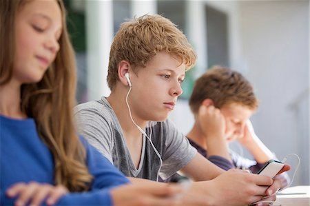 Students using electronic gadget in a classroom Stock Photo - Premium Royalty-Free, Code: 6108-06905270