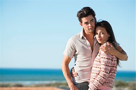Romantic couple standing on the beach Stock Photo - Premium Royalty-Free, Code: 6108-06905485