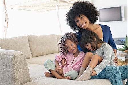 simsearch:6108-05872072,k - Smiling woman sitting with her two daughters Stock Photo - Premium Royalty-Free, Code: 6108-06905555