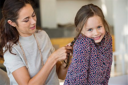 plaited - Smiling woman braiding her daughter's hair Stock Photo - Premium Royalty-Free, Code: 6108-06905576
