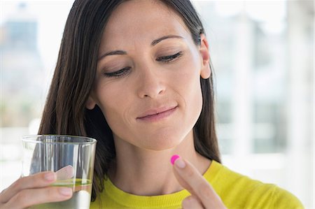 person eating alone - Close-up of a woman taking medicine Stock Photo - Premium Royalty-Free, Code: 6108-06905675