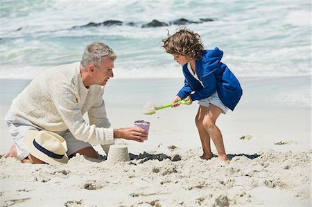 family life grandparent - Boy playing with his grandfather on the beach Stock Photo - Premium Royalty-Free, Code: 6108-06905892