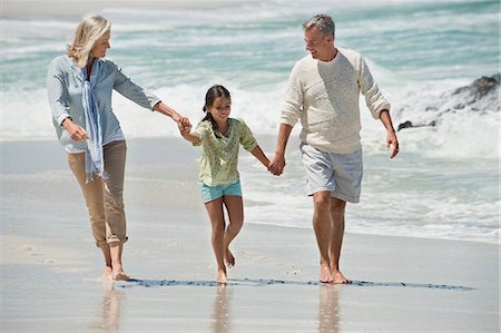 extended family walking outdoors - Girl walking with her grandparents on the beach Stock Photo - Premium Royalty-Free, Code: 6108-06905912