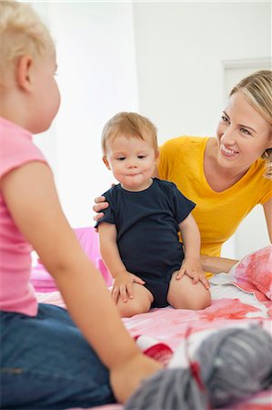 Woman playing with her children on the bed Stock Photo - Premium Royalty-Free, Code: 6108-06906062