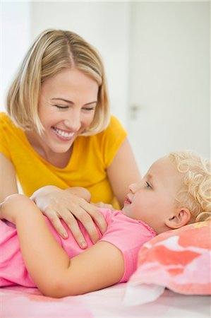 simsearch:6108-06907900,k - Smiling woman looking at her daughter lying on the bed Stock Photo - Premium Royalty-Free, Code: 6108-06906075