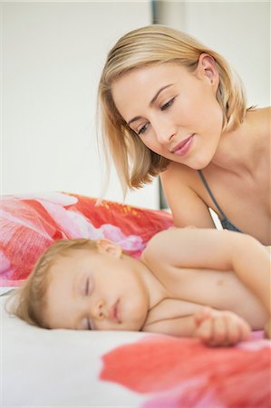 simsearch:6108-06907900,k - Woman looking at her baby sleeping on the bed Stock Photo - Premium Royalty-Free, Code: 6108-06906093
