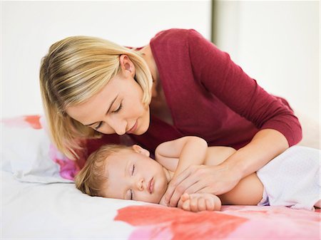 simsearch:693-03707745,k - Woman looking at her baby sleeping on the bed Stock Photo - Premium Royalty-Free, Code: 6108-06906095