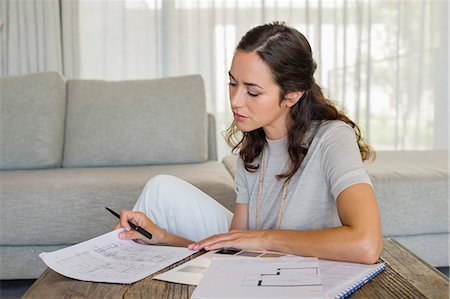 Woman doing paperwork at home Stock Photo - Premium Royalty-Free, Code: 6108-06906002