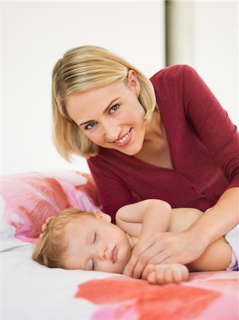 Woman near her baby sleeping on the bed Stock Photo - Premium Royalty-Free, Code: 6108-06906037