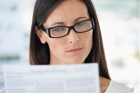 reading (understanding written words) - Close-up of a woman reading a document Stock Photo - Premium Royalty-Free, Code: 6108-06906177