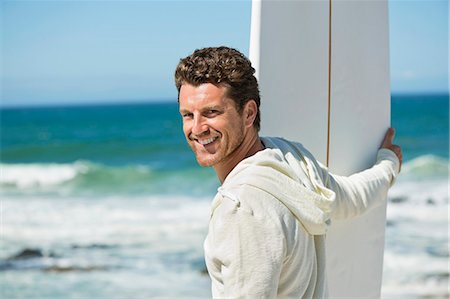 Man holding a surfboard on the beach Stock Photo - Premium Royalty-Free, Code: 6108-06906257