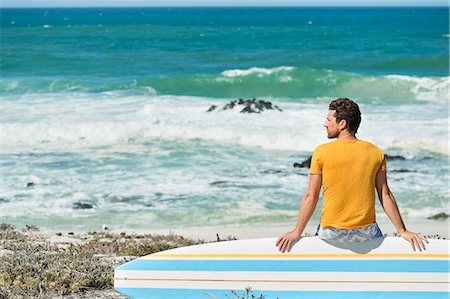 simsearch:6108-06906290,k - Man sitting on a surfboard on the beach Stock Photo - Premium Royalty-Free, Code: 6108-06906282