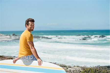 simsearch:6108-06906290,k - Man sitting on a surfboard on the beach Stock Photo - Premium Royalty-Free, Code: 6108-06906295