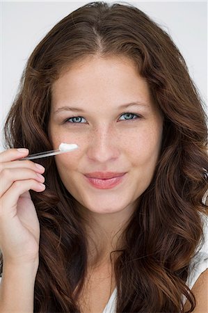 simsearch:6108-05869257,k - Portrait of a woman applying moisturizer cream on her face Stock Photo - Premium Royalty-Free, Code: 6108-06906349