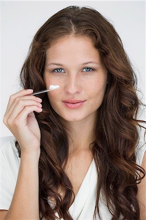 simsearch:6108-05869257,k - Portrait of a woman applying moisturizer cream on her face Stock Photo - Premium Royalty-Free, Code: 6108-06906378