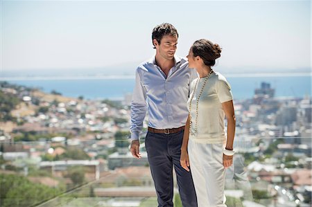 simsearch:6108-06907503,k - Couple looking at each other on a terrace with city in the background Stock Photo - Premium Royalty-Free, Code: 6108-06906411