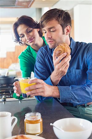 simsearch:6108-07969525,k - Couple having breakfast at a kitchen counter Stock Photo - Premium Royalty-Free, Code: 6108-06906418