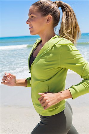 day to day routine - Smiling woman running on the beach Stock Photo - Premium Royalty-Free, Code: 6108-06906668