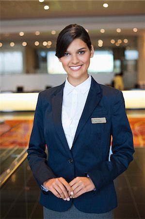 Portrait of a receptionist smiling in a hotel lobby Stock Photo - Premium Royalty-Free, Code: 6108-06906700