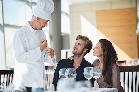 food and beverages hotel uniforms - Chef talking to couple at restaurant Stock Photo - Premium Royalty-Free, Code: 6108-06906706