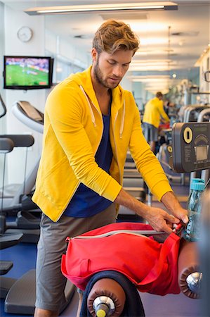 Man packing his bag in a gym after workout Foto de stock - Sin royalties Premium, Código: 6108-06906958