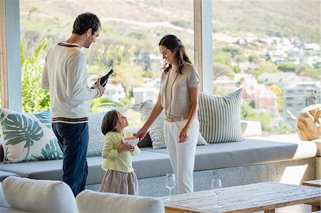 simsearch:6108-05872072,k - Couple standing in a living room with their daughter Stock Photo - Premium Royalty-Free, Code: 6108-06907147