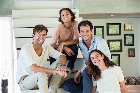 Portrait of smiling friends sitting on steps Stock Photo - Premium Royalty-Free, Code: 6108-06907169