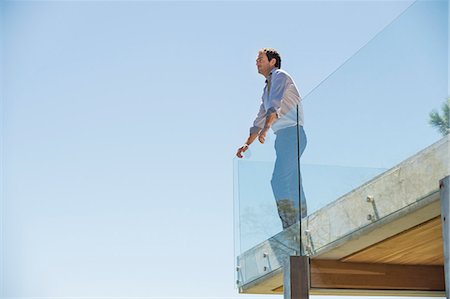side view railings glass - Man standing on the terrace looking away Stock Photo - Premium Royalty-Free, Code: 6108-06907187