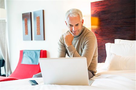 simsearch:6108-06904945,k - Man using a laptop in a hotel room Stock Photo - Premium Royalty-Free, Code: 6108-06907119