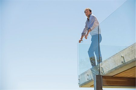 side view railings glass - Man standing on the terrace looking away Stock Photo - Premium Royalty-Free, Code: 6108-06907121