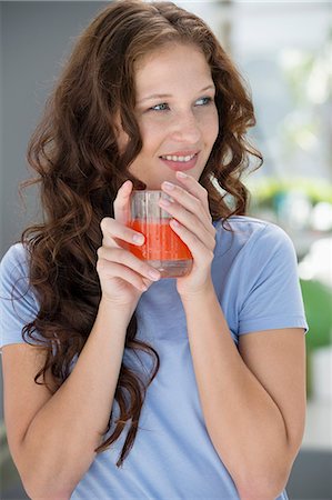 simsearch:6108-07969525,k - Smiling woman holding a glass of orange juice Stock Photo - Premium Royalty-Free, Code: 6108-06907441