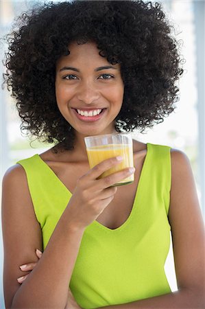 simsearch:6108-07969525,k - Portrait of a smiling woman holding a glass of mango shake Stock Photo - Premium Royalty-Free, Code: 6108-06907425