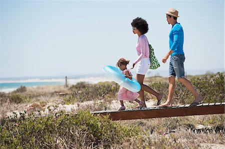 Family walking on a boardwalk on the beach Stock Photo - Premium Royalty-Free, Code: 6108-06907591