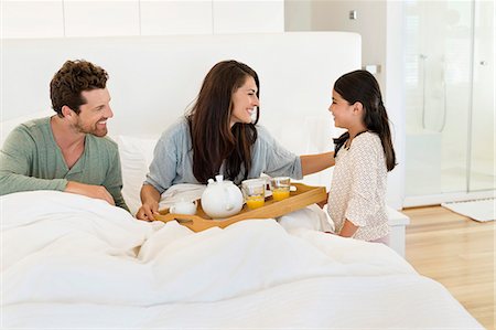 simsearch:6108-06907900,k - Girl serving tea to her parents on the bed Stock Photo - Premium Royalty-Free, Code: 6108-06907663