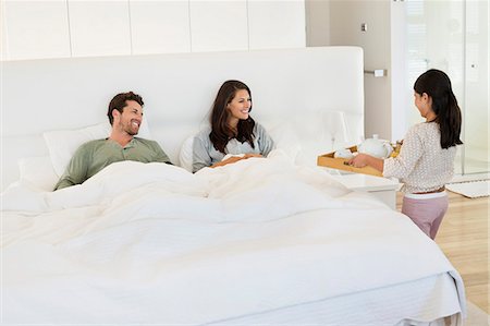 simsearch:6108-05872072,k - Girl serving tea to her parents on the bed Stock Photo - Premium Royalty-Free, Code: 6108-06907660