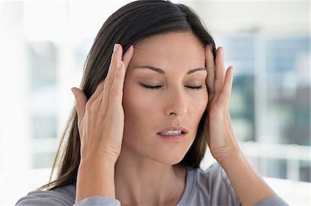 Close-up of a woman suffering from a headache Stock Photo - Premium Royalty-Free, Code: 6108-06907749