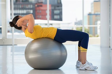 Woman exercising on a fitness ball in a gym Stock Photo - Premium Royalty-Free, Code: 6108-06907795