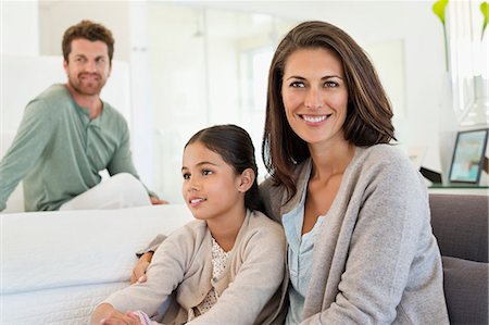 simsearch:6108-05872072,k - Woman sitting with her daughter and her husband in the background Stock Photo - Premium Royalty-Free, Code: 6108-06907893