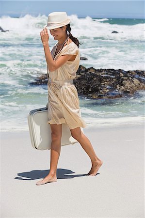 simsearch:6108-06907957,k - Beautiful woman carrying a suitcase on the beach Stock Photo - Premium Royalty-Free, Code: 6108-06907943