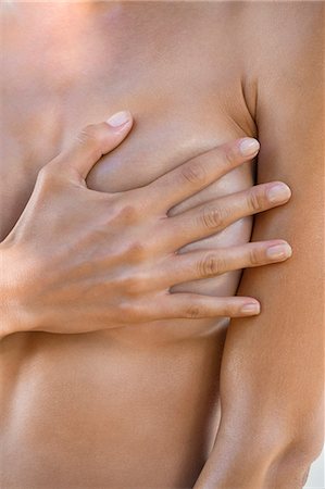 finger - Close-up of a woman hiding her breast with her hand Stock Photo - Premium Royalty-Free, Code: 6108-06908069