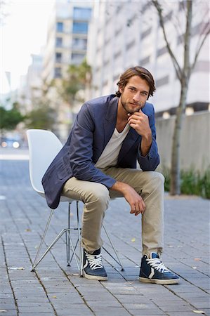 relaxar - Portrait of a man sitting on a chair on a street Foto de stock - Royalty Free Premium, Número: 6108-06908150