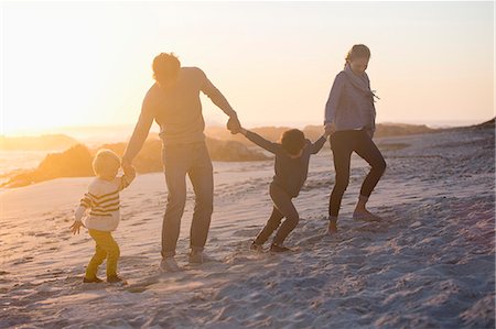 Parents with their children walking on the beach Stock Photo - Premium Royalty-Free, Code: 6108-08662395