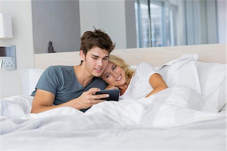 simsearch:6108-06166423,k - Couple watching movie on digital tablet on the bed Foto de stock - Sin royalties Premium, Código: 6108-08662541