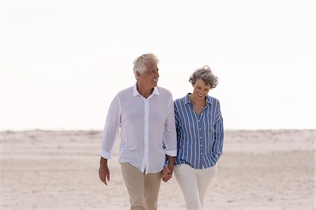 Happy senior couple walking on beach Stock Photo - Premium Royalty-Free, Code: 6108-08662687