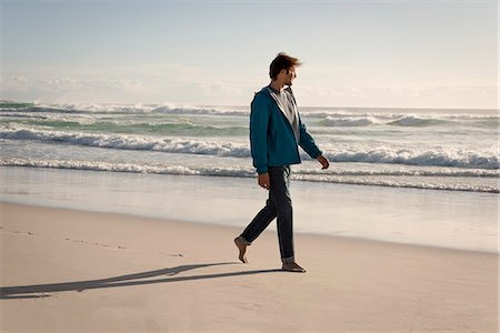 Happy young man walking on beach Stock Photo - Premium Royalty-Free, Code: 6108-08662637