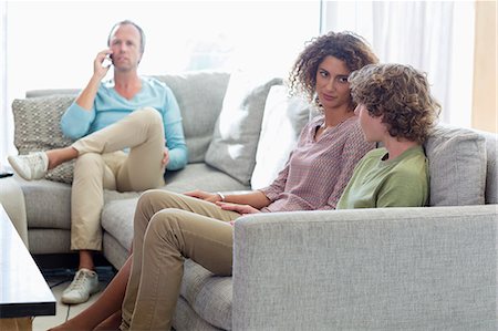 Happy family sitting in a living room at home Stock Photo - Premium Royalty-Free, Code: 6108-08662774