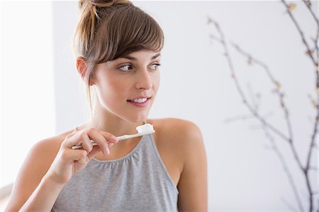 Close-up of a young beautiful woman brushing her teeth Stock Photo - Premium Royalty-Free, Code: 6108-08662848