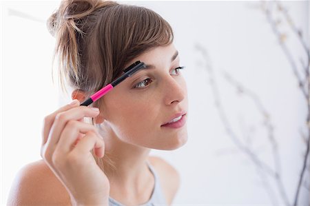 elegant woman looking away - Close-up of a woman applying mascara Stock Photo - Premium Royalty-Free, Code: 6108-08662852